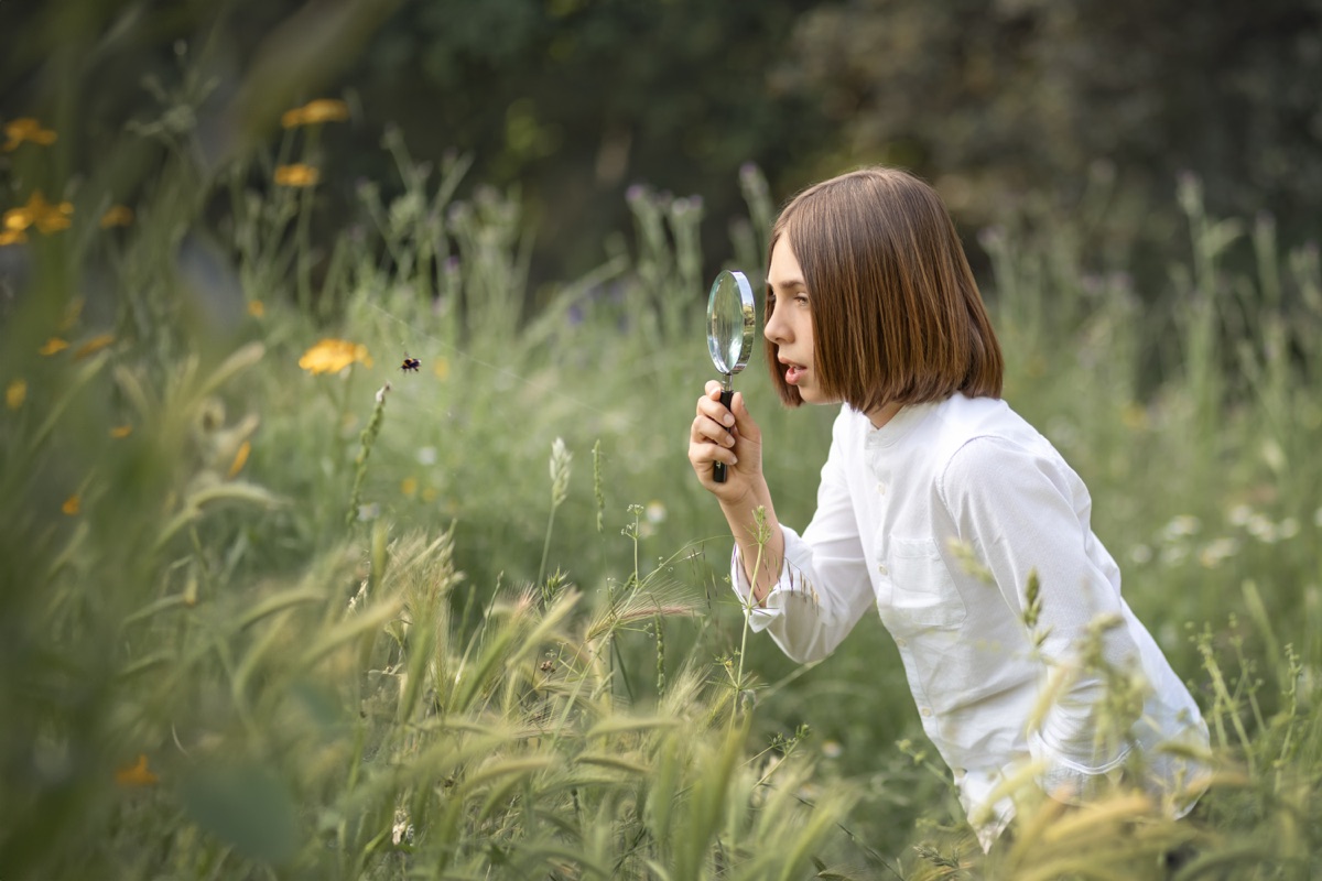 Retrato de una niña de Comunión con flores en un entorno natural.