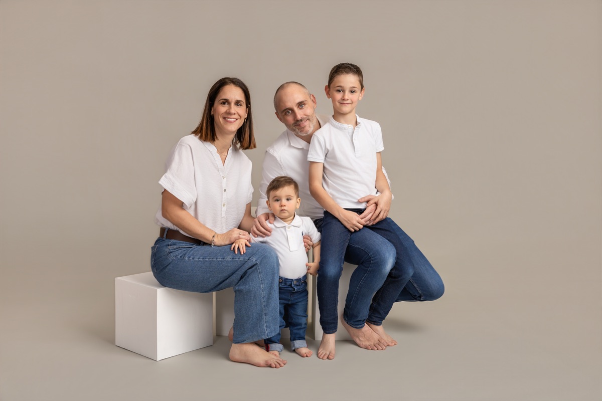 Una familia de cuatro comparte un retrato sentado sobre cubos en el estudio