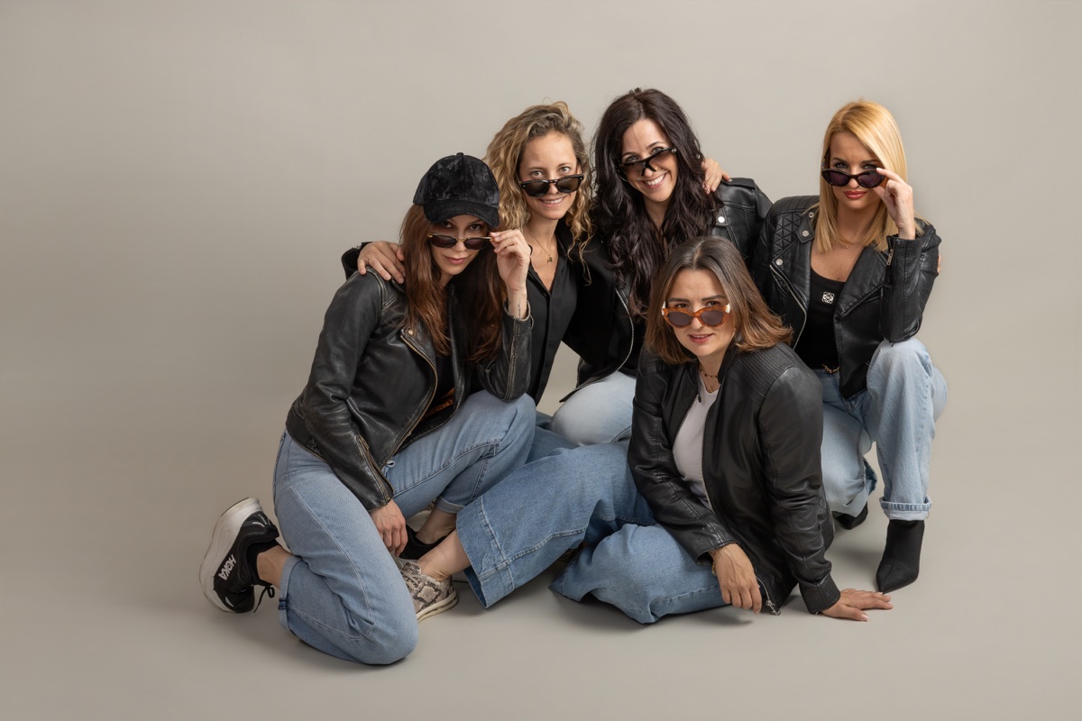 Cinco amigas posan juntas con gafas de sol en una sesión de grupo