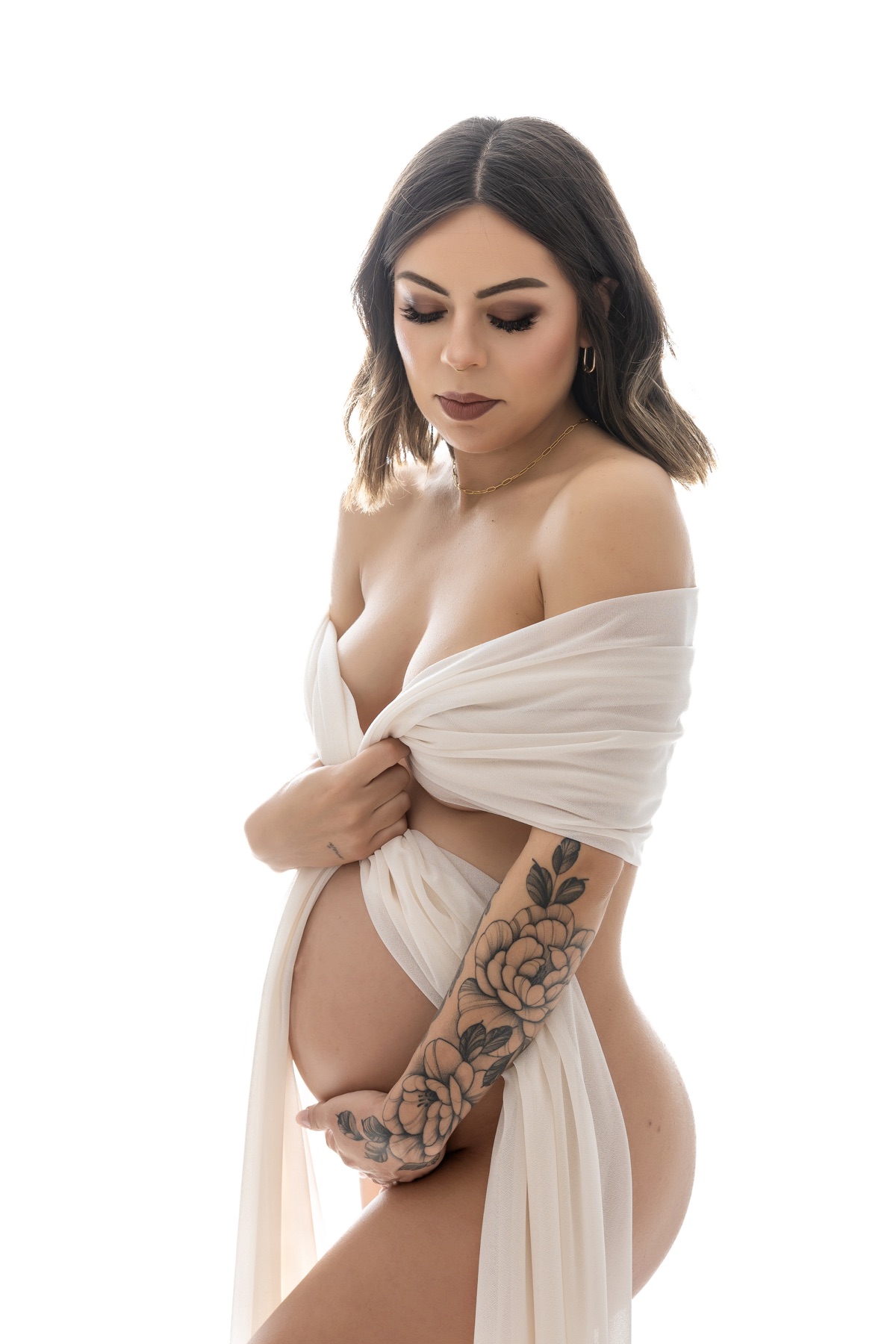 Retrato de embarazo de estilo casual con top negro y vaqueros en el estudio