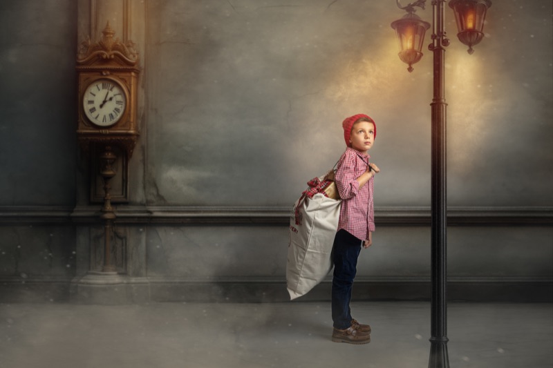 Niña con una cartera de viaje junto a un reloj y una farola antigua