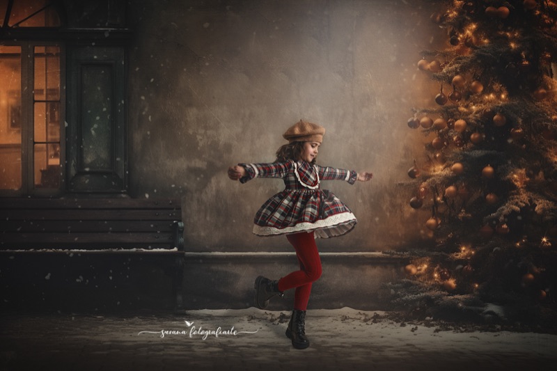 Niña jugando al aire libre durante una sesión navideña