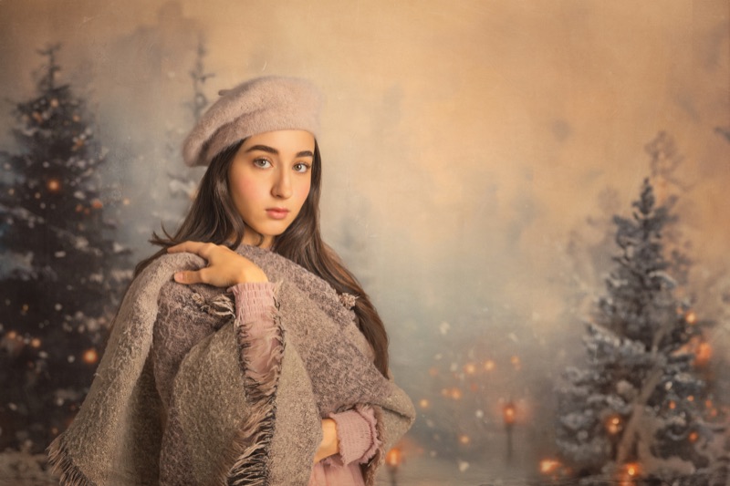 Retrato navideño de una joven con boina en un escenario invernal iluminado