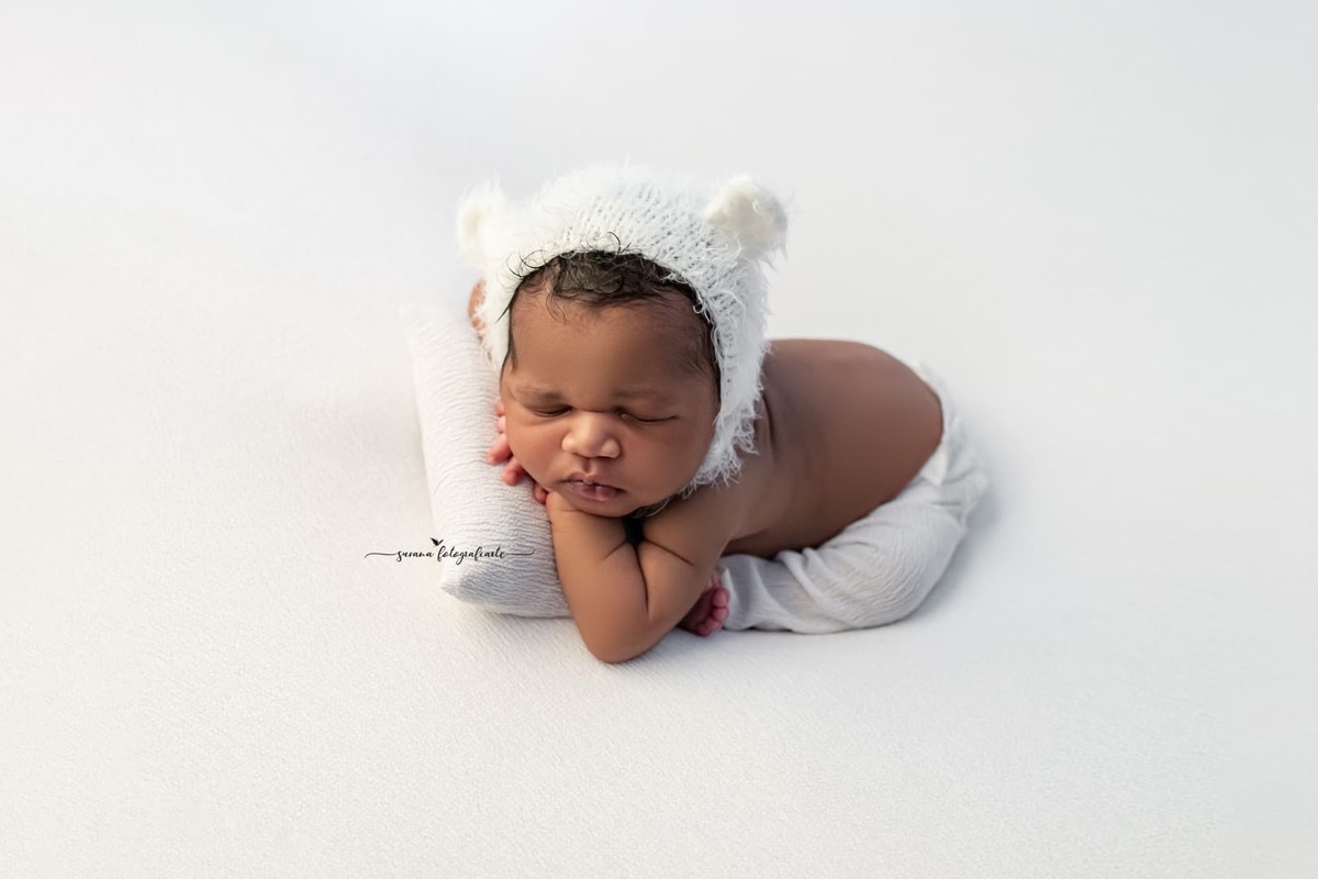 Bebé recién nacido con gorrito sobre una almohada en un estudio de fotografía de Villanueva de la Cañada