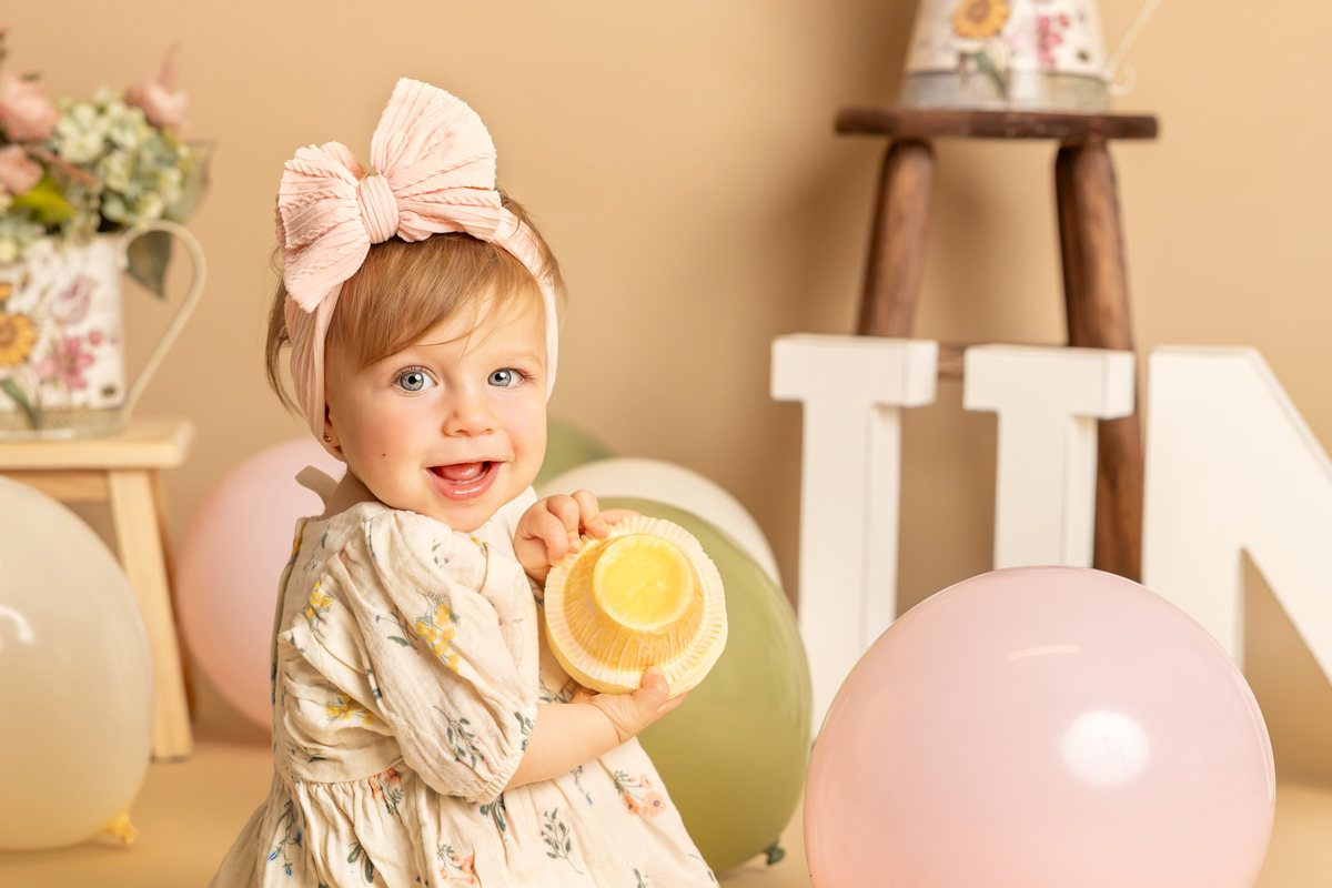 Retrato de una bebé con globo pastel en una sesión Smash Cake.
