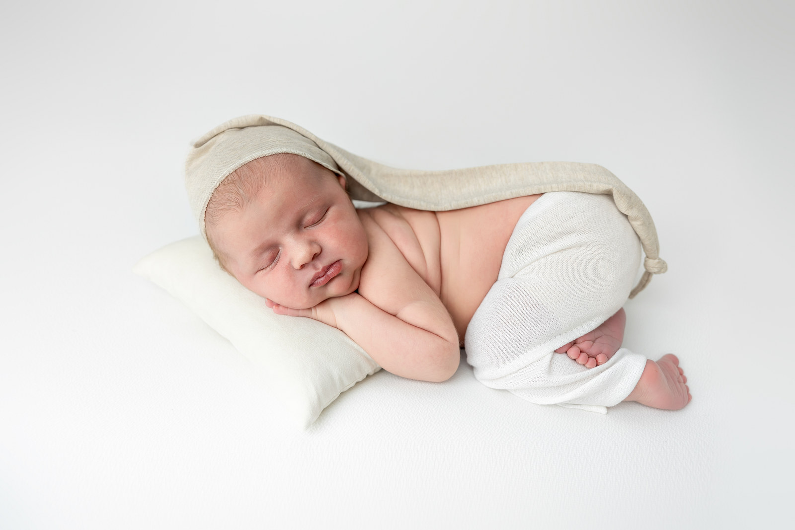 Bebé recién nacido dormido y envuelto durante una sesión de fotografía newborn